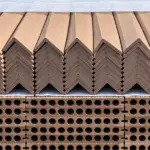 Composite L-angle trims stacked on a pallet above decking boards