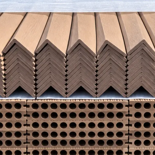 Composite L-angle trims stacked on a pallet above decking boards